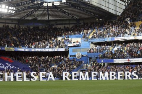 Fans observe a minutes silence for victims of the Leicester City helicopter crash including chairman Vichai Srivaddhanaprabha and Armistice Day ahead of the English Premier League soccer match between Chelsea and Everton at Stamford Bridge stadium in London, Sunday, Nov. 11, 2018. (AP Photo/Tim Ireland)