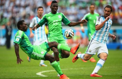PORTO ALEGRE, BRAZIL - JUNE 25: Juwon Oshaniwa of Nigeria (L) tries to clear the ball as teammate Kenneth Omeruo and Gonzalo Higuain of Argentina run on during the 2014 FIFA World Cup Brazil Group F match between Nigeria and Argentina at Estadio Beira-Rio on June 25, 2014 in Porto Alegre, Brazil.  (Photo by Ian Walton/Getty Images)