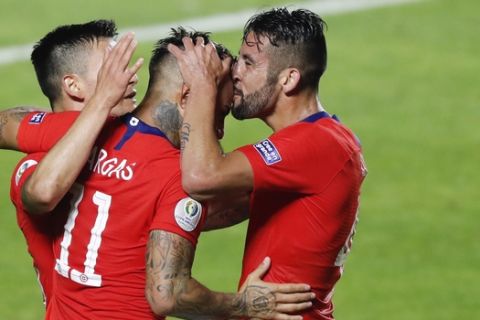 Chile's Mauricio Isla, right kisses Chile's Eduardo Vargas, center, as he celebrates scoring his side's 4th goal during a Copa America Group C soccer match against Japan at the Morumbi stadium in Sao Paulo, Brazil, Monday, June 17, 2019. (AP Photo/Nelson Antoine)