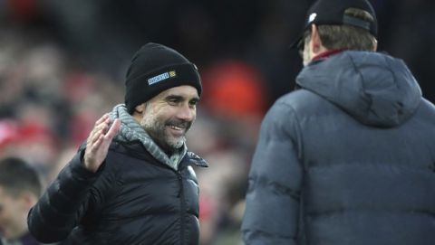 Manchester City's head coach Pep Guardiola, left, shakes hand with Liverpool's manager Jurgen Klopp prior to the start of the English Premier League soccer match between Liverpool and Manchester City at Anfield stadium in Liverpool, England, Sunday, Nov. 10, 2019. (AP Photo/Jon Super)
