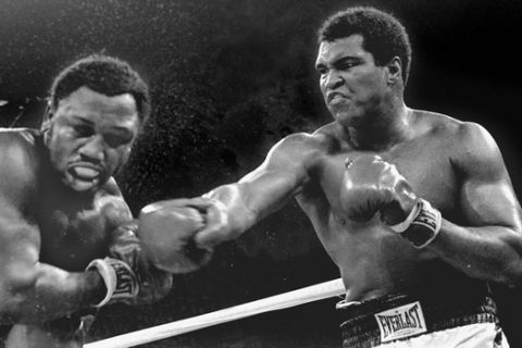 FILE - In this Oct. 1, 1975, file photo, spray flies from the head of challenger Joe Frazier as heavyweight champion Muhammad Ali connects with a right in the ninth round of their title fight in Manila, Philippines. Ali, the magnificent heavyweight champion whose fast fists and irrepressible personality transcended sports and captivated the world, has died according to a statement released by his family Friday, June 3, 2016. He was 74. (AP Photo/Mitsunori Chigita, File)