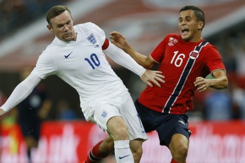 England's Wayne Rooney, left, clashes with Norway's Omar Elabdellaoui during the international friendly soccer match between England and Norway at Wembley Stadium in London, Wednesday, Sept. 3, 2014. (AP Photo/Kirsty Wigglesworth) 