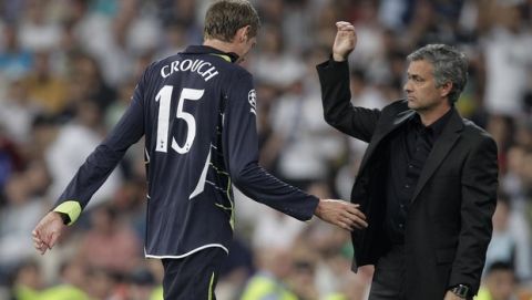 Tottenham Hotspur's Peter Crouch, left, walks past Real Madrid's coach Jose Mourinho from Portugal after getting sent off, during a quarter final, 1st leg Champions League soccer match at the Santiago Bernabeu stadium in Madrid, Tuesday April 5, 2011. (AP Photo/Paul White)