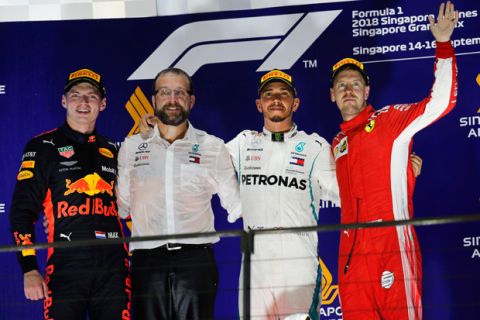 Mercedes driver Lewis Hamilton of Britain, center, poses after winning the Singapore Formula One Grand Prix, Red Bull Racing driver Max Verstappen of Netherlands, left, and Ferrari driver Sebastian Vettel of Germany, right, during the awards ceremony at the Marina Bay City Circuit in Singapore, Sunday, Sept. 16, 2018. (AP Photo/Vincent Thian)