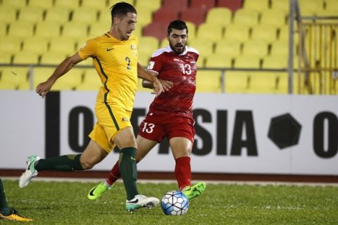 Australia's Milos Degenek, left, fight for control of the ball with Syria's Yousef Kalfa during the 2018 World Cup qualifying football match between Syria and Australia at the Hang Jebat Stadium in Melaka, Malaysia, Thursday, Oct. 5, 2017. (AP Photo/Vincent Thian)