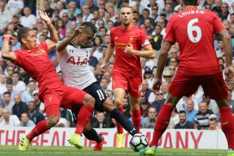 Liverpool's Roberto Firmino, left, blocks the shot of Tottenham's Erik Lamela, second left, while Liverpool's Jordan Henderson, second right, and Liverpool's Dejan Lovren look on during the English Premier League soccer match between Tottenham Hotspur and Liverpool at White Hart Lane in London, Saturday, Aug. 27, 2016. (AP Photo/Tim Ireland)