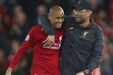 Liverpool's coach Juergen Klopp hugs Liverpool's Fabinho after the Champions League Group C soccer match between Liverpool and Paris-Saint-Germain at Anfield stadium in Liverpool, England, Tuesday, Sept. 18, 2018. Liverpool won the match 3-2. (AP Photo/Dave Thompson)