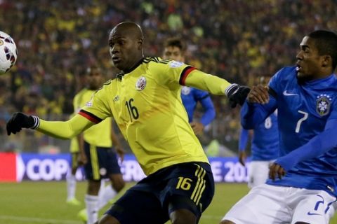 Colombia's Victor Ibarbo, left, fight for the ball with Brazil's Douglas Costa during a Copa America Group C soccer match at the Monumental stadium in Santiago, Chile, Wednesday, June 17, 2015. Colombia won the match 1-0. (AP Photo/Ricardo Mazalan)