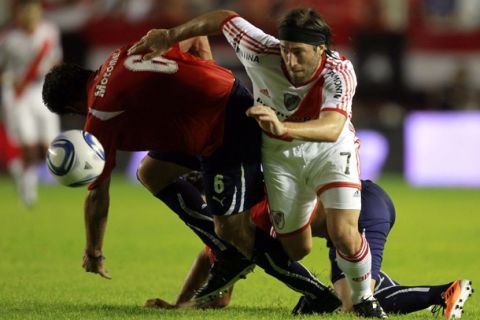 River Plate's Mariano Pavone fights for the ball with Independiente's Eduardo Tuzzio (L) during their Argentine First Division soccer match in Avellaneda, on the outskirts of Buenos Aires, February 27, 2011.  REUTERS/Marcos Brindicci (ARGENTINA - Tags: SPORT SOCCER)