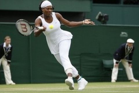 Serena Williams, wearing long trousers following an attack of cramp, returns to Daniela Hantuchova during their Women's Singles match on the Centre Court at Wimbledon, Monday July 2, 2007.(AP Photo/Anja Niedringhaus) ** EDITORIAL USE ONLY **