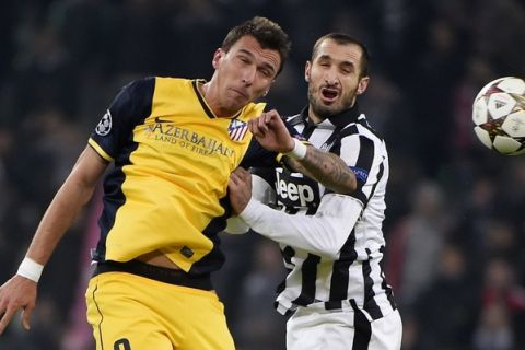 Atletico Madrid's Croatian forward Mario Mandzukic (L) voes with Juventus' defender Giorgio Chiellini during the UEFA Champions League football match Juventus vs Atletico Madrid at the "Juventus Stadium" in Turin on December 9, 2014.      AFP PHOTO / OLIVIER MORIN        (Photo credit should read OLIVIER MORIN/AFP/Getty Images)