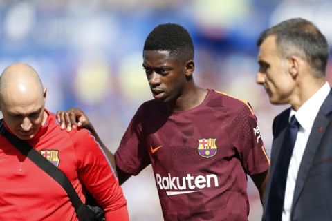 Barcelona's Ousmane Dembele, centre, leaves the pitch injured during a Spanish La Liga soccer match between Getafe and Barcelona at the Alfonso Perez stadium in Getafe, outside Madrid, Saturday, Sept. 16, 2017. Barcelona won 2-1. (AP Photo/Francisco Seco)