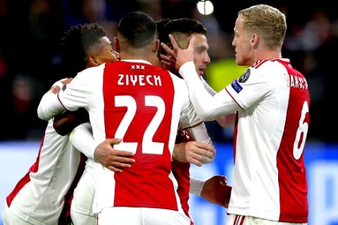 Ajax's Dusan Tadic, center, celebrates with team mates after scoring his side's opening goal during the Champions League group E soccer match between Ajax and FC Bayern Munich at the Johan Cruyff Arena in Amsterdam, Netherlands, Wednesday, Dec. 12, 2018. (AP Photo/Peter Dejong)