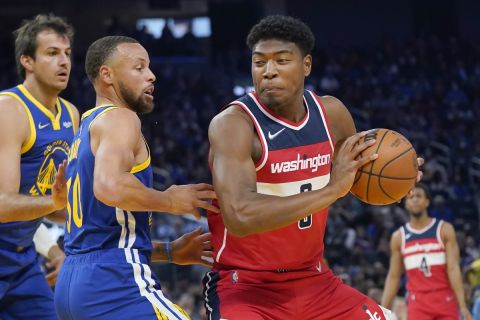Washington Wizards forward Rui Hachimura, right, is defended by Golden State Warriors guard Stephen Curry during the first half of an NBA basketball game in San Francisco, Monday, March 14, 2022. (AP Photo/Jeff Chiu)
