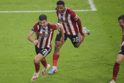 Sheffield United's John Egan, left, celebrates after scoring during the English Premier League soccer match between Sheffield United and Wolverhampton Wanderers at Bramall Lane stadium in Sheffield, England, Wednesday, July 8, 2020. (Laurence Griffiths/Pool via AP)