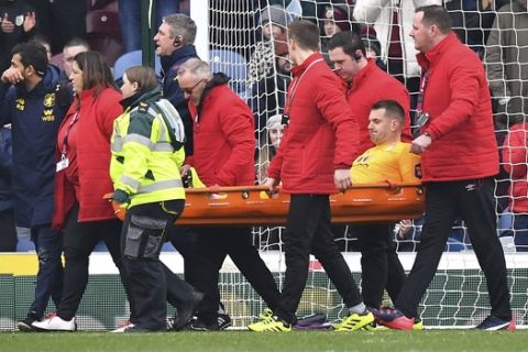 Aston Villa goalkeeper Tom Heaton, centre, is carried off the pitch on a stretcher, during the English Premier League soccer match between Burnley and Aston Villa, at Turf Moor, Burnley, England, Wednesday Jan. 1, 2020. (Anthony Devlin/PA via AP)