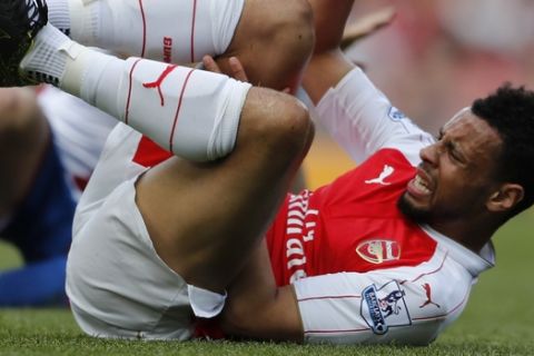 Arsenal's Francis Coquelin lies injured following a tackle during the English Premier League soccer match between Arsenal and Crystal Palace at the Emirates stadium in London, Sunday, April 17,  2016. (AP Photo/Frank Augstein)