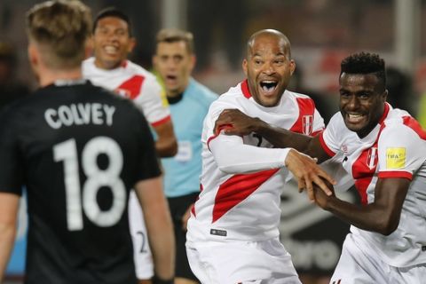 Peru's Christian Ramos, right,. celebrates after scoring his side's second goal against New Zealand, with his teammate Alberto Rodriguez , center, during a play-off qualifying match for the 2018 Russian World Cup in Lima, Peru, Wednesday, Nov. 15, 2017.  Peru won the match 2-0 and qualified for the World Cup for the first time in 36 years. (AP Photo/Karel Navarro)