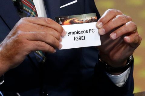 Former player Andres Palop shows the draw Olympiacos FC, during the Europa League draw ceremony of the first round of the 2016/2017 Europa League, at the Grimaldi Forum, in Monaco, Friday, Aug. 26, 2016. (AP Photo/Claude Paris)