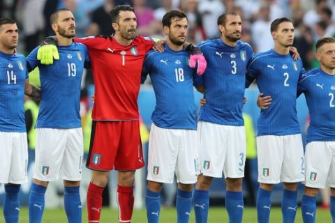 Italian players stand on the pitch to honor the victims of the attack in a Dhaka's restaurant, Bangladesh, during the Euro 2016 quarterfinal soccer match between Germany and Italy, at the Nouveau Stade in Bordeaux, France, Saturday, July 2, 2016. (AP Photo/Thanassis Stavrakis)