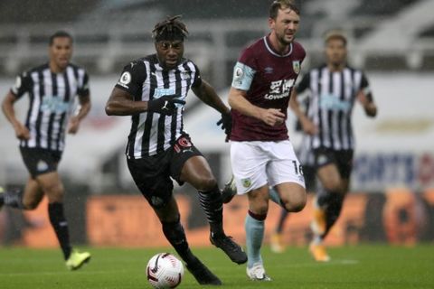 Newcastle's Allan Saint-Maximin, front left, duels for the ball with Burnley's Dale Stephens during the English Premier League soccer match between Newcastle United and Burnley at St. James' Park in Newcastle, England, Saturday, Oct. 3, 2020. (Alex Pantling/Pool via AP)