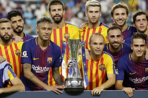 Barcelona's Neymar, second from left front, and teammates pose with the trophy after defeating Real Madrid in an International Champions Cup soccer match, Saturday, July 29, 2017, in Miami Gardens, Fla. (AP Photo/Lynne Sladky)