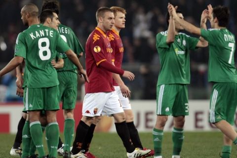 Panathinaikos' players, in green, celebrate past AS Roma's Daniele De Rossi, at center in foreground red jersey, and teammate John Arne Riise at the end of the UEFA Europa League round of 32 second leg soccer match between AS Roma and Panathinaikos, in Rome, Thursday, Feb. 25, 2010. Panathinaikos won 3-2.  (AP Photo/Gregorio Borgia)