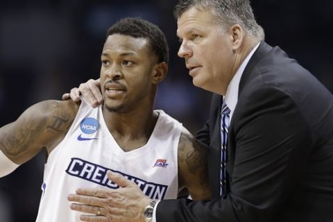 Creighton coach Greg McDermott, right, talks with Marcus Foster during the second half of the team's first-round game against Kansas State in the NCAA men's college basketball tournament in Charlotte, N.C., Friday, March 16, 2018. (AP Photo/Gerry Broome)