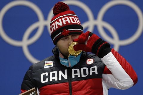 Gold medalist in the men's ski cross Brady Leman, of Canada, kisses his medal during the medals ceremony at the 2018 Winter Olympics in Pyeongchang, South Korea, Wednesday, Feb. 21, 2018. (AP Photo/Charlie Riedel)