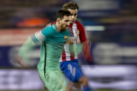 FC Barcelona's Leo Messi, left, duels for the ball with Atletico de Madrid Antoine Griezmann during a Spanish Copa del Rey semifinal first round soccer match between Atletico de Madrid and FC Barcelona at the Vicente Calderon stadium in Madrid, Spain, Wednesday, Feb. 1, 2017. (AP Photo/Daniel Ochoa de Olza)
