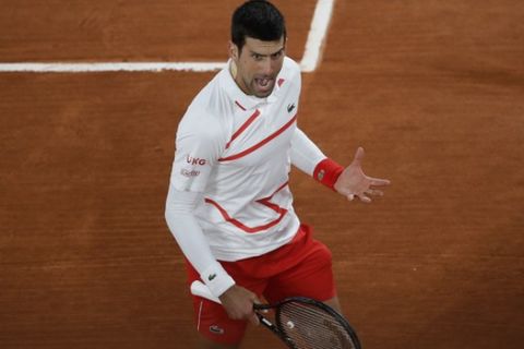 Serbia's Novak Djokovic screams after playing a shot against Spain's Pablo Carreno Busta in the quarterfinal match of the French Open tennis tournament at the Roland Garros stadium in Paris, France, Wednesday, Oct. 7, 2020. (AP Photo/Alessandra Tarantino)