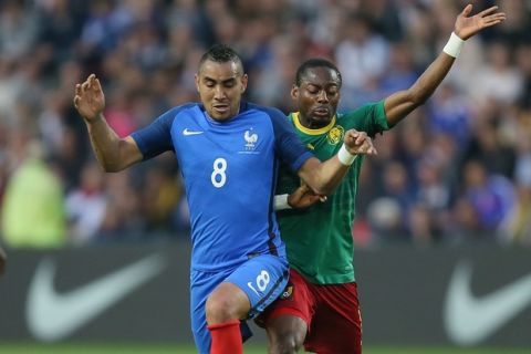 France's Dimitri Payet, right, challenges for the ball with Cameroon's Eyong Enoh Tarkang during a friendly soccer match between France and Cameroon at the La Beaujoire Stadium in Nantes, western France, Monday, May 30, 2016. The French squad is in preparation for the EURO 2016 soccer championships which will start on June 10, 2016. (AP Photo/David Vincent)