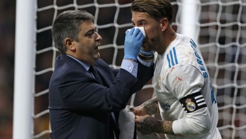 Real Madrid's Sergio Ramos, right, with his jersey stained with blood is cared for by a team's doctor during the Spanish La Liga soccer match between Real Madrid and Atletico at the Wanda Metropolitano stadium in Madrid, Saturday, Nov 18, 2017. (AP Photo/Francisco Seco)