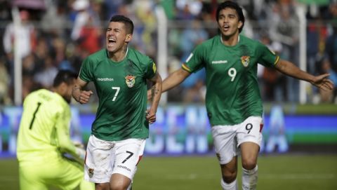 Bolivia's Juan Carlos Arce (7) celebrates scoring his side's first goal against Argentina followed by teammate Marcelo Martins during a 2018 World Cup qualifying match in La Paz, Bolivia, on Tuesday, March 28, 2017. (AP Photo/Victor R. Caivano)