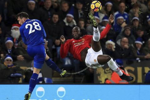 Leicester City's Christian Fuchs, left, and Manchester United's Romelu Lukaku battle for the ball during their English Premier League soccer match at the King Power Stadium, Leicester, England, Saturday, Dec. 23, 2017. (Mike Egerton/PA via AP)