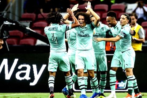 Arsenal players celebrate after Mesut Oil scored their first goal during the International Champions Cup match between Arsenal and Paris Saint-Germain in Singapore, Saturday, July 28, 2018. (AP Photo/Yong Teck Lim)