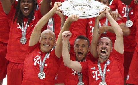 Front from left, Bayern's Arjen Robben, Rafinha and Franck Ribery lift the trophy to celebrate Bayern's 7th straight Bundesliga title after the German Soccer Bundesliga match between FC Bayern Munich and Eintracht Frankfurt in Munich, Germany, Saturday, May 18, 2019. (AP Photo/Matthias Schrader)
