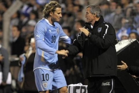 Uruguay's Diego Forlan, left, shakes hands with Uruguay's Oscar Tabarez as he leaves the field after being substituted during a friendly soccer match ahead of the upcoming 2011 Copa America against Estonia in Rivera, some 500 km north of Montevideo, Uruguay, Thursday, June 23, 2011. Argentina will host the Copa America soccer tournament from July 1 to July 24. (AP Photo/Matilde Campodonico) 