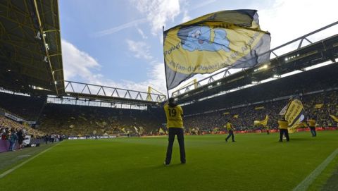 Fans wave flags prior the German Bundesliga soccer match between Borussia Dortmund and Bayer Leverkusen at the Signal-Iduna Park in Dortmund, Germany, Saturday, Aug. 23, 2014, 2014. (AP Photo/Martin Meissner)