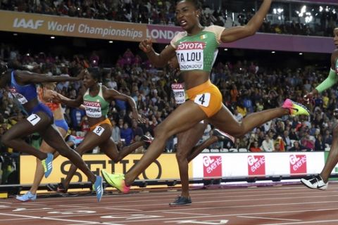 United States' Tori Bowie, left, crosses the line to win the gold in the women's 100-meter final during the World Athletics Championships in London Sunday, Aug. 6, 2017. (AP Photo/Matthias Schrader)
