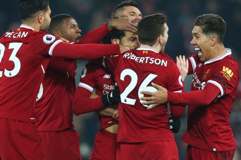 Liverpool players celebrate with Mohamed Salah, center, after he scored his side's fourth goal during the English Premier League soccer match between Liverpool and Manchester City at Anfield Stadium, in Liverpool, England, Sunday Jan. 14, 2018. (AP Photo/Dave Thompson)