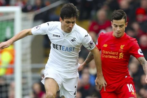 Swansea City's Jack Cork, left, and Liverpool's Philippe Coutinho battle for the ball during the English Premier League soccer match between Liverpool and Swansea City at Anfield, Liverpool, England, Saturday, Jan. 21, 2017. (Peter Byrne/PA via AP)