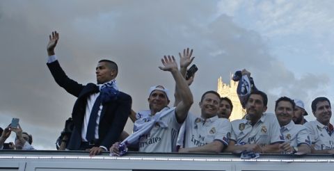Real Madrid's Cristiano Ronaldo, left, waves on top of an open-topped bus in Cibeles square to celebrate with the team after winning the Champions League final, Madrid, Spain, Sunday June 4, 2017. Real Madrid became the first team in the Champions League era to win back-to-back titles with their 4-1 victory over Juventus in Cardiff Saturday. (AP Photo/Paul White)