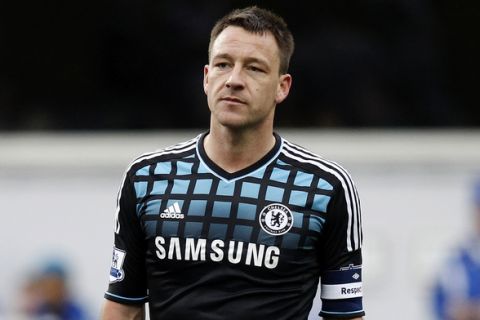 John Terry of Chelsea looks over at the Queens Park Rangers fans as they chant insults at him during an injury break in their FA Cup soccer match at Loftus Road in London, January 28, 2012.  REUTERS/Andrew Winning (BRITAIN - Tags: SPORT SOCCER)