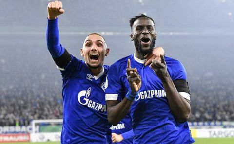 Schalke's Salif Sane, right, celebrates after scoring his side's second goal with first scorer Ahmed Kutucu, left, during the German soccer cup, DFB Pokal, match between FC Schalke 04 and Fortuna Duesseldorf in Gelsenkirchen, Germany, Wednesday, Feb. 6, 2019. (AP Photo/Martin Meissner)
