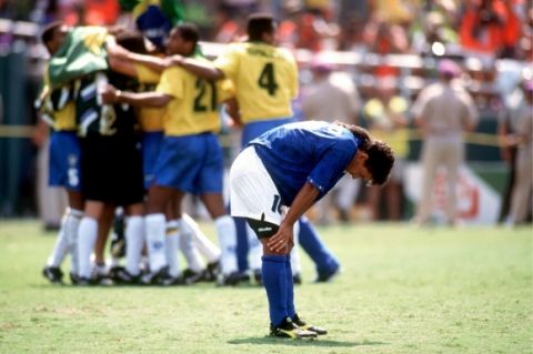Roberto Baggio of Italy shows his disappointment after missing his penalty as Brazil celebrate
