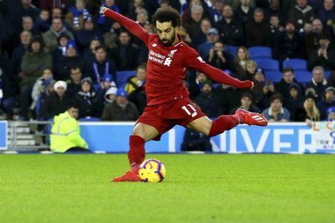Liverpool's Mohamed Salah scores his side's first goal of the game from the penalty spot during the English Premier League soccer match between Brighton and Hove Albion and Liverpool F.C at the Vitality Stadium, Brighton England. Saturday, Jan. 12, 2019. (Gareth Fuller/PA via AP)