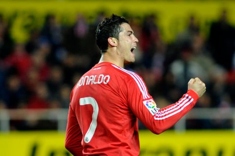 Real Madrid's Portuguese forward Cristiano Ronaldo celebrates after a scoring of his team against Sevilla during their Spanish League football match, on December 17, 2011 at Ramon Sanchez Pizjuan stadium in Sevilla. Real Madrid won 6-2.    AFP PHOTO/ CRISTINA QUICLER (Photo credit should read CRISTINA QUICLER/AFP/Getty Images)
