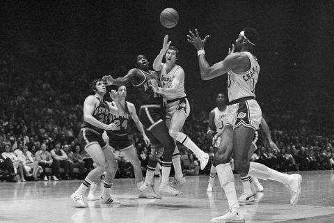 FILE - Los Angeles Lakers Jerry West, right, passes the ball Monday night, April 28, 1970, during game with the New York Knickerbockers at New York's Madison Square Garden. Covering West are Knicks Willis Reed (19), left, and Walt Frazier (10), center. (AP Photo, File)