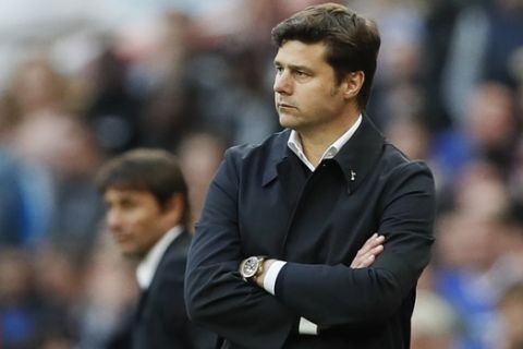 Tottenham Hotspur's head coach Mauricio Pochettino stands with his arms folded with Chelsea's manager Antonio Conte watching at left during the English FA Cup semifinal soccer match between Chelsea and Tottenham Hotspur at Wembley stadium in London, Saturday, April 22, 2017. (AP Photo/Kirsty Wigglesworth)